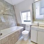 Bathroom Renovation completed using large tiles in beige colour and white bathroom suite